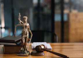 Statue of lady justice on desk of a judge or lawyer.